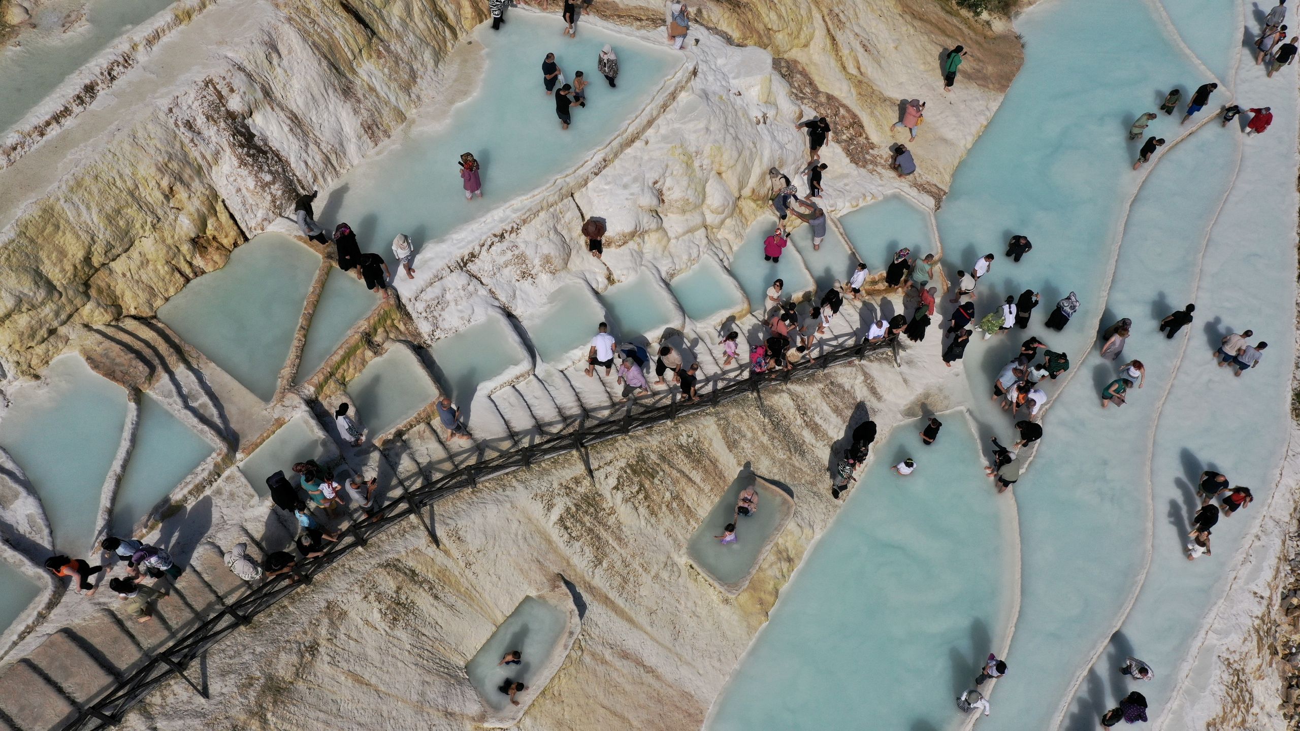 GIRESUN, TURKIYE - AUGUST 28: An aerial view of locals and tourists visiting the Goksu travertines, known as Giresun's Pamukkale (means 'cotton castle') and known for its mineral-rich waters flowing down white travertine terraces and turquoise colored ponds on a nearby hillside, in Dereli district of Giresun, Turkiye on August 28, 2024. Goksu travertines, gaining recognition through promotional activities in recent years, contribute to the tourism activities of the district. (Photo by Gultekin Yetgin/Anadolu via Getty Images)