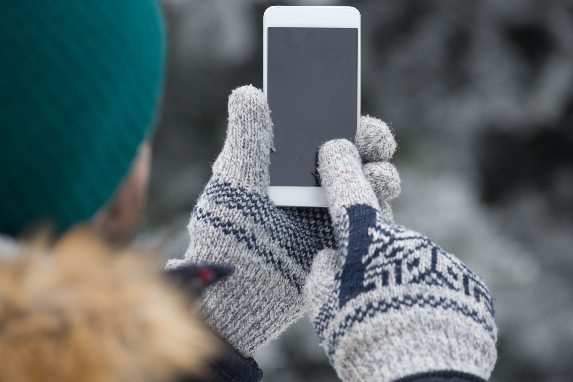 Close up of man hand in woolen gloves holding blank screen smart phone.people, mobile, winter, blank, touch, transportation, travel, owner, smart, cellphone, trip, snow, down, concept, cell, road, person, app, smartphone, wireless, telephone, gloves, holding, phone, cold, technology, screen, problem, copy space, hand, outdoor, green, wooden, snow day, man
