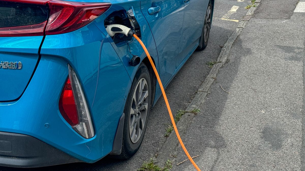 BATH, UNITED KINGDOM - AUGUST 13: A electric car is recharged by a cable while it is parked on a residential street, on August 13, 2024 in Bath, England. Critics of electric cars have raised concerns about how they will be charged by owners who live in terraced housing or have homes without parking. The government's commitment to reducing future Co2 carbon emissions will mean many more motorists will need to switch from petrol and diesel powered cars to electric (EV) driven ones. However there are also fears that the charging network in the UK is not yet fit to deal with the enormous demand more EVs on the road would place on it.(Photo by Matt Cardy/Getty Images)
