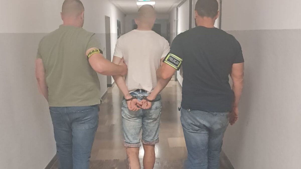 Policjanci prowadzą zatrzymanego mężczyznę