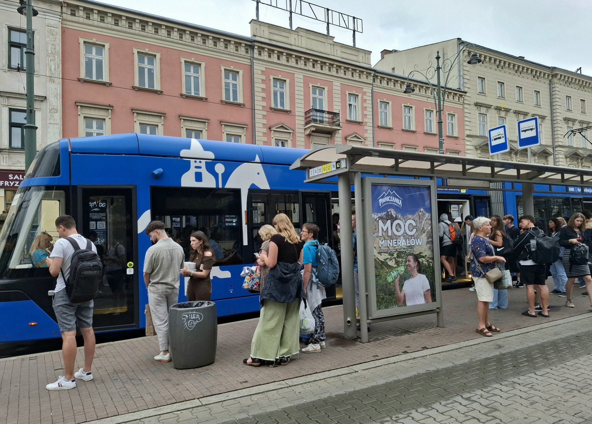 Przystanek tramwajowo-autobusowy &#34;Teatr Słowackiego 01&#34; w Krakowie. Pod jedną wiatą tramwaj i autobus, pod drugą – rozkłady jazdy. Zarząd Transportu Publicznego w Krakowie obiecał przyjrzeć się sytuacji.