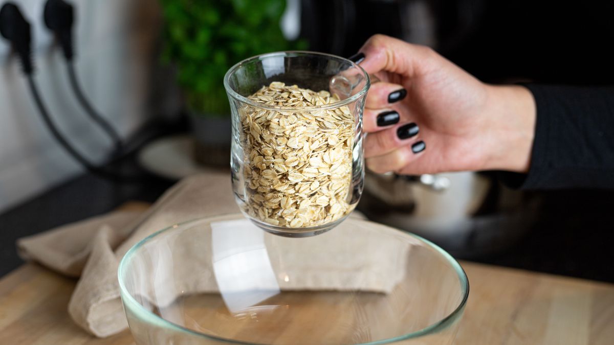 Płatki owsiane przesypywane ze szklanki do szklanej miski