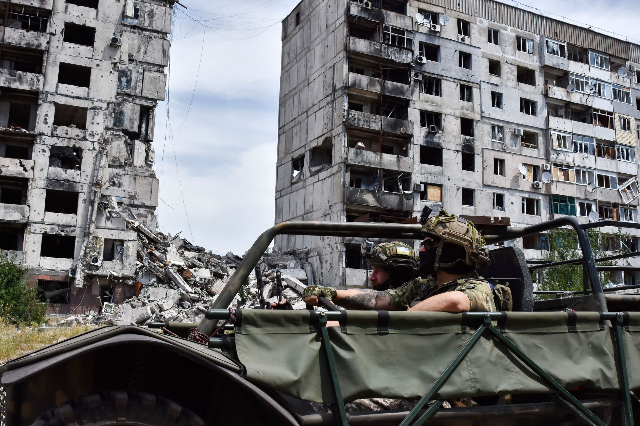 ORIKHIV, ZAPORIZHZHIA, UKRAINE - 2024/07/10: Ukrainian soldiers from the evacuation team of 65th Separate Mechanized brigade drive in the evacuation buggy near an apartment building heavily damaged by the Russian shelling in Orikhiv. Ukrainian defenders use beach buggies, ATVs (All-terrain Vehicle) and electric bicycles at the front because these vehicles are quieter and harder to see and hear. This gives soldiers on the front line a better chance of avoiding Russian drones and surviving. These small vehicles were no substitute for traditional military vehicles. They lack the firepower and space to carry large numbers of people or cargo, and their lack of armour leaves everyone on board vulnerable. But these alternative means of transport fill a niche that soldiers on the front line say has become necessary. (Photo by Andriy Andriyenko/SOPA Images/LightRocket via Getty Images)