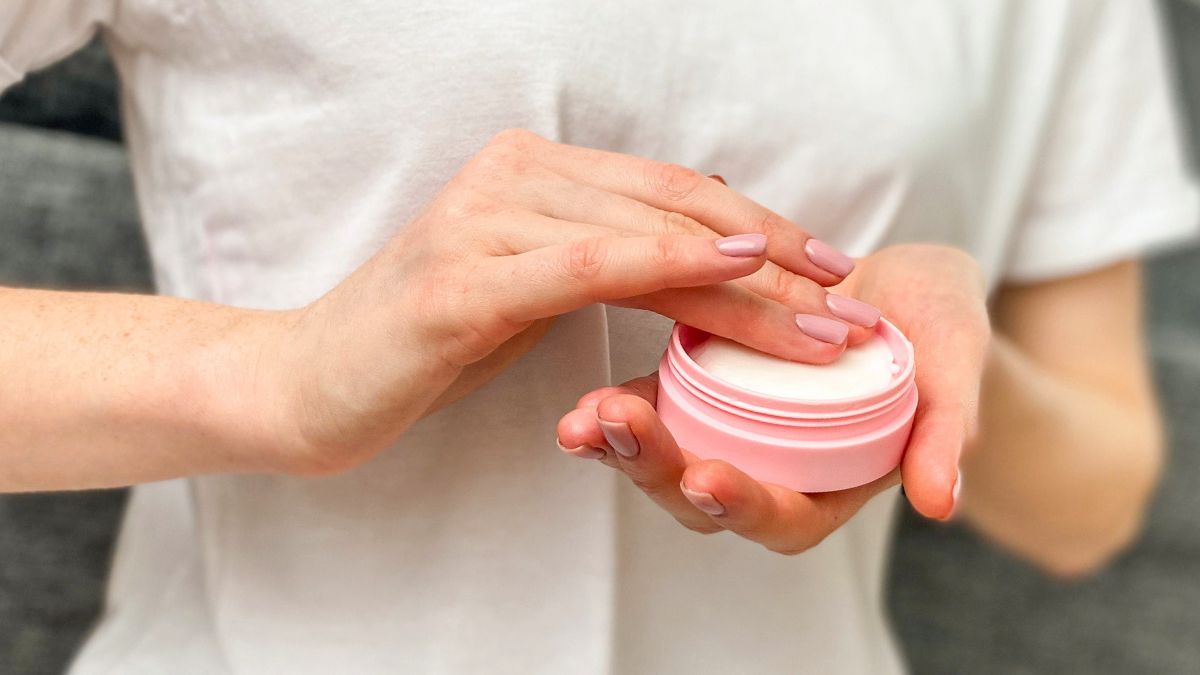 Kobieta trzyma w dłoniach krem
