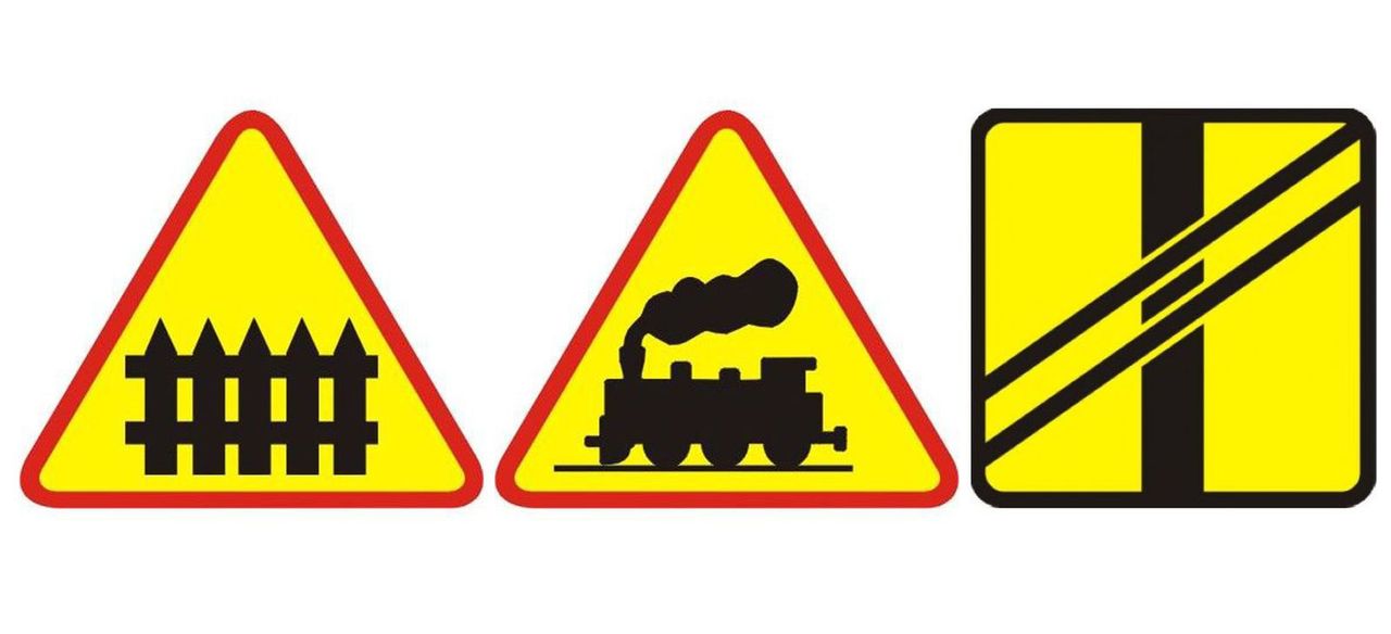 Od lewej znaki:A-9: przejazd kolejowy z zaporamiA-10: przejazd kolejowy bez zapórT-7: tabliczka pokazująca układ torów i drogi na przejeździe bez zapór
