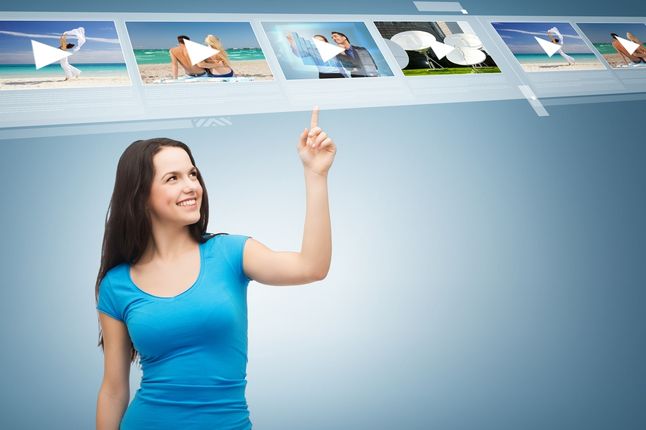Zdjęcie advertisement concept - attractive teenager in casual clothes pointing her finger at videos pochodzi z serwisu Shutterstock