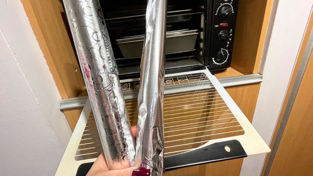 Folia aluminiowa trzymana przy otwartym piekarniku