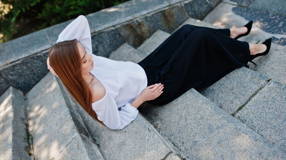 Do czarnych szerokich spodni w kant dobierz białą bluzkę i czarne szpilki