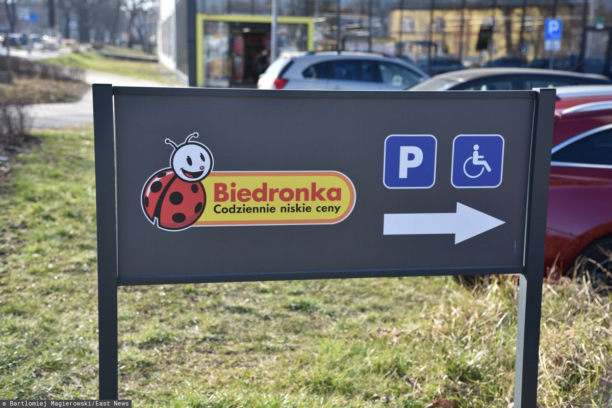 Wjazd na parking i logo dyskontu Biedronka.