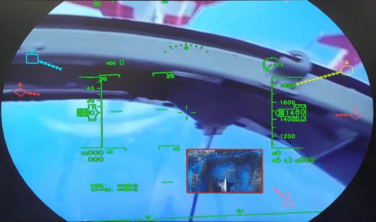 Wizualizacja obrazu jaki otrzymuje pilot używający systemu Striker II. Obraz zewnętrzny jest wyświetlany dodatkowo w celu lepszego zaprezentowania możliwości systemu. Zwraca uwagę dodatkowe okno graficzne na dole pola obserwacji, prezentujące obraz celu pochodzący z kamery bezzałogowca, przesłane do samolotu przy pomocy łącza danych.