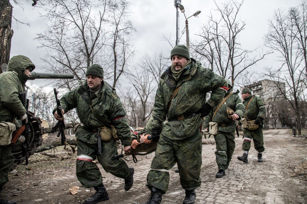Soldiers of the DNR (Donetsk People's Republic) run with aMARIUPOL, UKRAINE - 2022/03/27: Soldiers of the DNR (Donetsk People's Republic) run with a stretcher carrying an injured separatist in a contested area of Mariupol. The battle between Russian / Pro Russian forces and the defending Ukrainian forces led by the Azov battalion continues in the port city of Mariupol. (Photo by Maximilian Clarke/SOPA Images/LightRocket via Getty Images)SOPA Imagesannexation, attack, devastation, fight, invasion, kiev, russian, war against ukraine, humanitarian crisis, man, male, dnr, soldier, soldiers, wounded, injured, guns, weapons