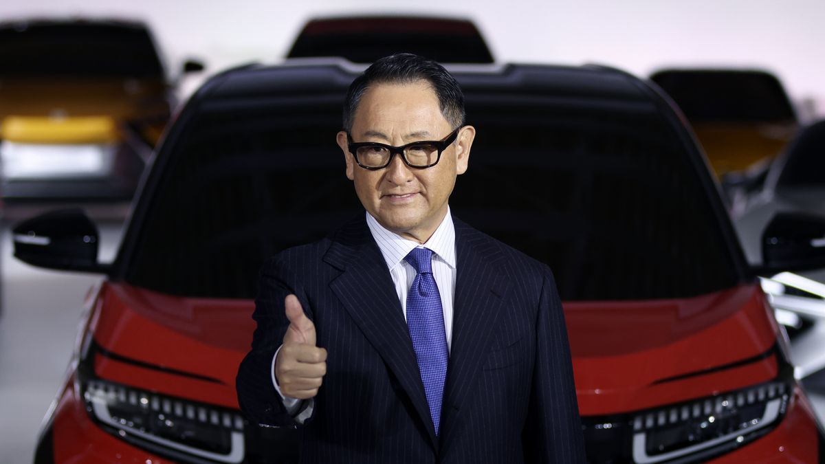 Akio Toyoda, president of Toyota Motor Corp., gestures while posing for photographs during a news conference at the company's showroom in Tokyo, Japan, on Tuesday, Dec. 14, 2021. The worlds biggest carmaker is planning to invest 4 trillion yen ($35.2 billion) to supercharge its EV push, with a target to sell 3.5 million units annually by the end of the decade, according to Toyoda. Toyota will roll out 30 electric models by 2030, a step up from a prior plan to introduce 15 EVs globally by 2025. Photographer: Kiyoshi Ota/Bloomberg via Getty Images