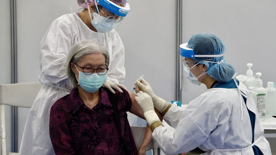 epa09272130 A resident receives a jab of AstraZeneca (Vaxzevria) COVID-19 vaccine during a mass vaccination event in New Taipei city, Taiwan, 15 June 2021. Taiwan started administering the 1.24 million shots of AstraZeneca vaccine it received from Japan.  EPA/RITCHIE B. TONGO Dostawca: PAP/EPA.