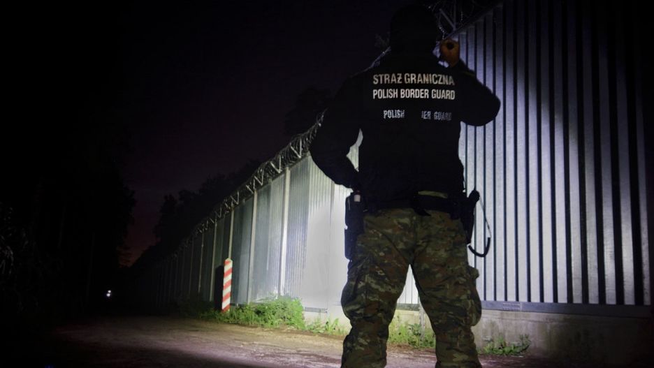 Kryzys migracyjny na granicy polsko-białoruskiej. Na fot. strażnik sprawdza stan bariery 