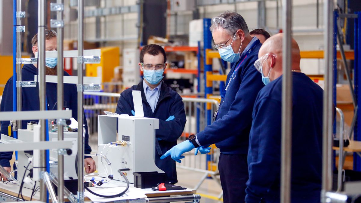 Engineers talk in front of a flow meter on the ventilator production line in an adapted hangar at the Airbus SE assembly plant in Broughton, U.K., on Thursday, April 30, 2020. Industrial giants like Airbus, Siemens AG and Ford Motor Co. will lend factory floors and supply chain heft to meet government orders for 5,000 ventilator machines of the Smiths Group Plc design, which is already approved by medical authorities, and 15,000 Penlon Ltd. devices. Photographer: Paul Thomas/Bloomberg via Getty Images