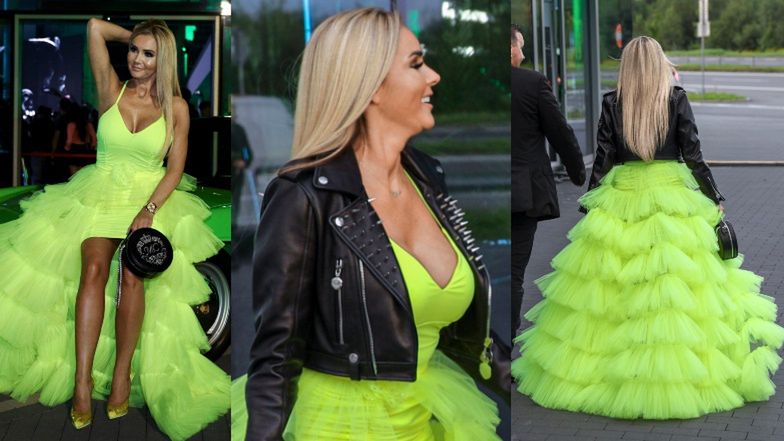 Wydekoltowana Monika Chwajoł w falbaniastej kreacji wypina się na masce samochodu