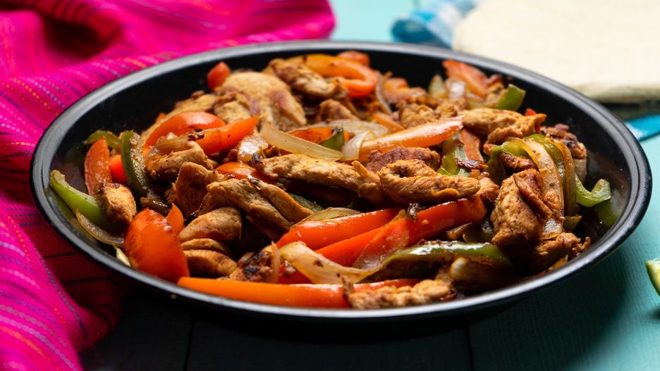 Mexican chicken fajitas on turquoise background