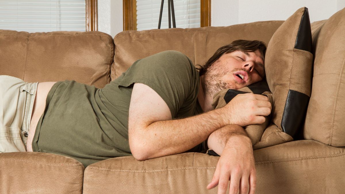 Mężczyzna śpi na kanapie.