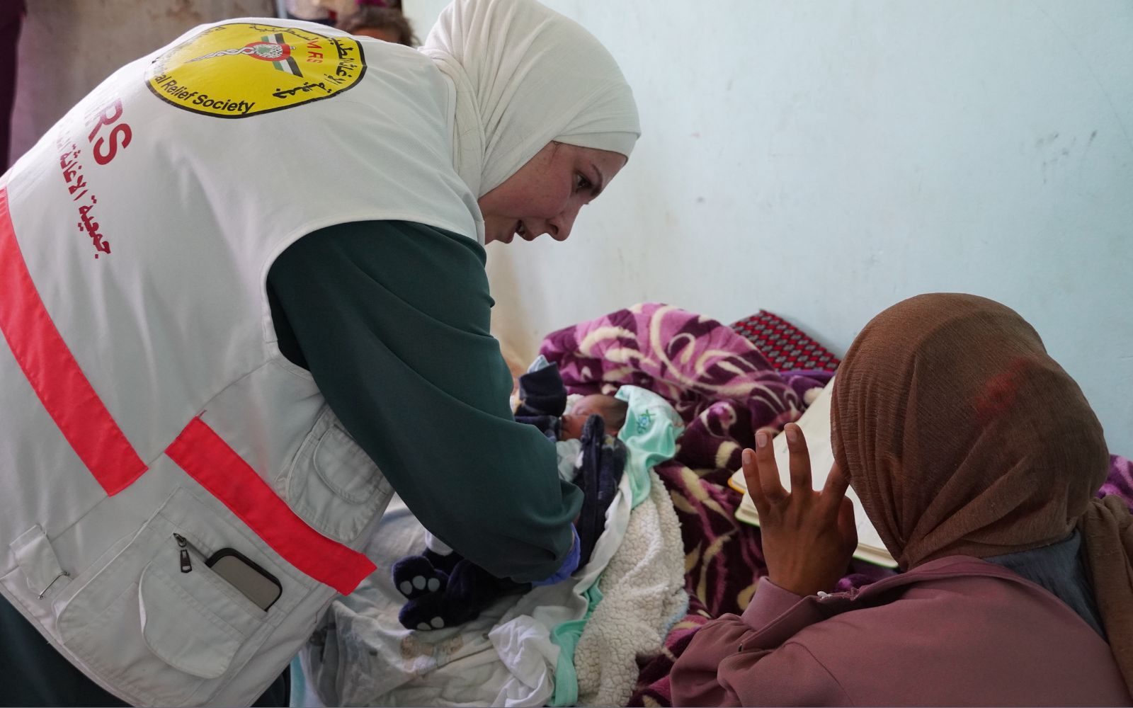 Na zdjęciu: Rodzina z malutkim dzieckiem z wolontariuszką PMRS