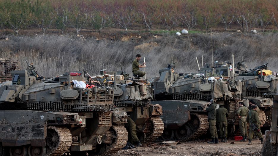 Israeli soldiers walk past tanks parked in a field upon returning to Israel following a ceasefire with Hezbollah, in Metula, northern Israel, 28 November 2024. A 60-day ceasefire agreement between Israel and Hezbollah came into force on 27 November. EPA/ATEF SAFADI Dostawca: PAP/EPA.