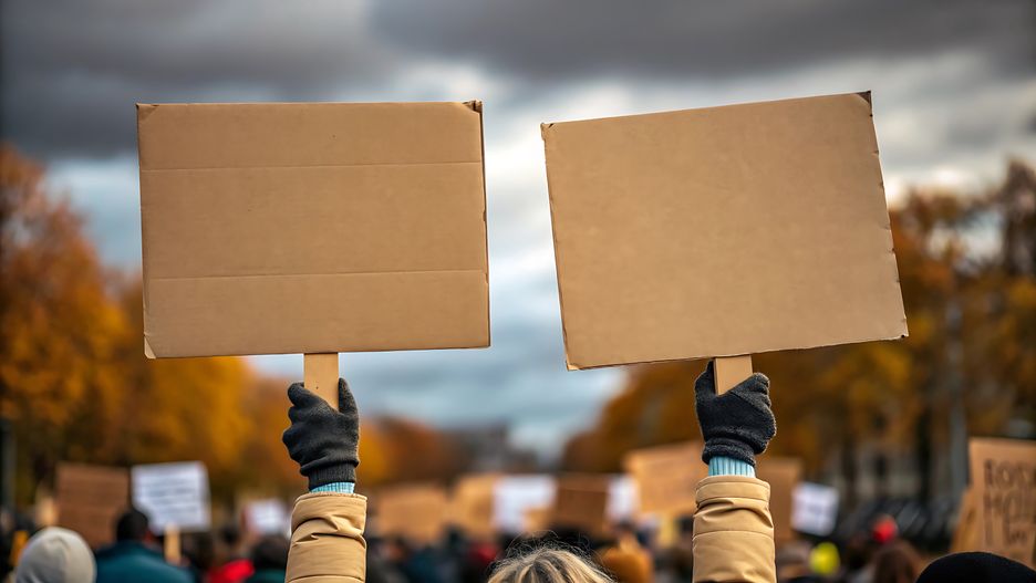 A close-up shot shows two blank brown cardboard signs held up by gloved hands. The signs are positioned side-by-side, with the left sign slightly closer to the camera. In the background, a blurred crowd of people and autumn trees under a cloudy sky suggest an outdoor public gathering or demonstration.
protest, protest, demonstration, demonstration, cardboard, cardboard, signs, signs, blank, blank, empty, empty, holding, holding, hands, hands, gloves, gloves, crowd, crowd, people, people, autumn, autumn, trees, trees, outdoors, outdoors, public, public, gathering, gathering, message, message, activism, activism, social, social, issue, issue, movement, movement, rally, rally, expression, expression, communication, communication, support, support, protest, demonstration, cardboard, signs, blank, empty, holding, hands, gloves, crowd, people, autumn, trees, outdoors, public, gathering, message, activism, social, issue, movement, rally, expression, communication, support
