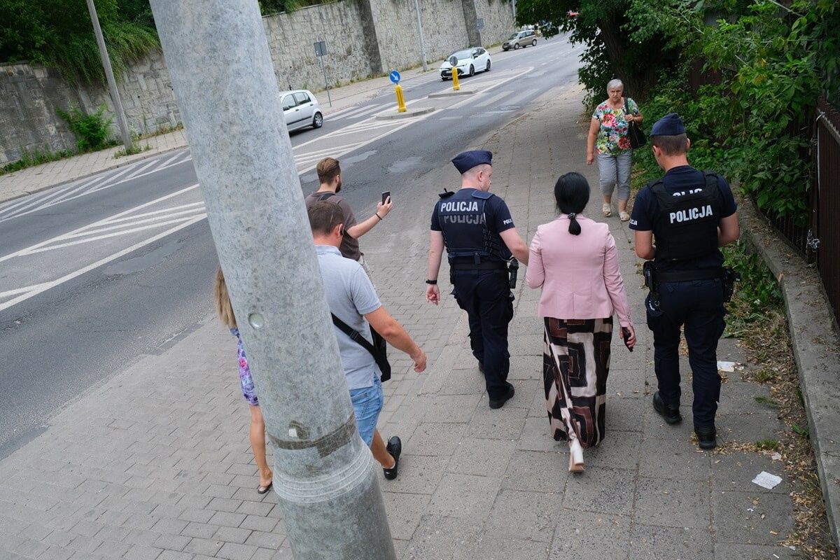 Prezes Lubelskich Dworców Anna Kusiak w asyście policji i idący za nimi handlarze z targowiska przy ul. Ruskiej