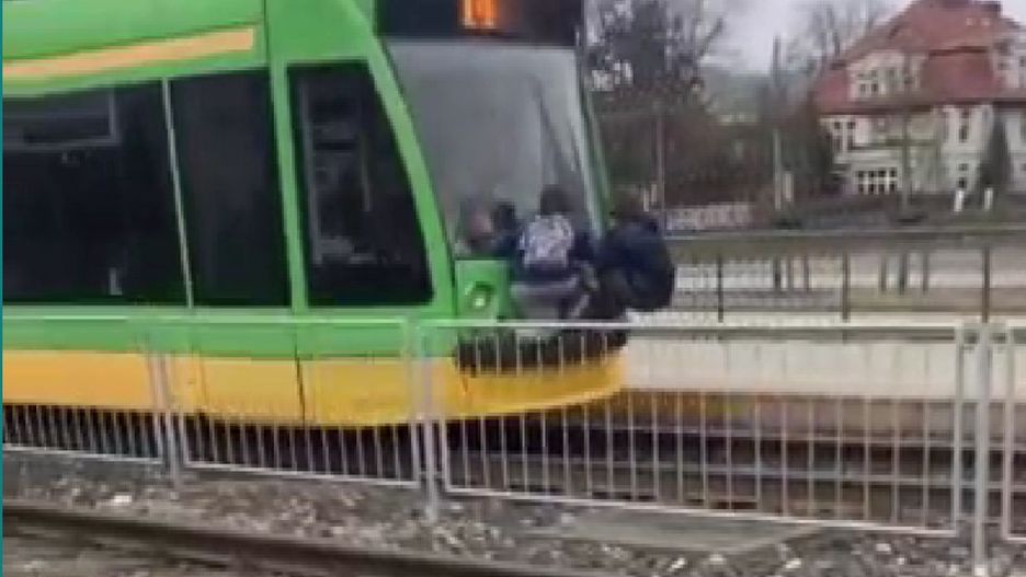 Młodzież jadąc z tyłu tramwaju