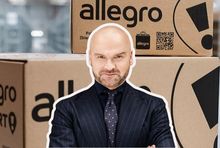 Rafał Brzoska na tle paczek z Allegro, fot. mat. prasowe