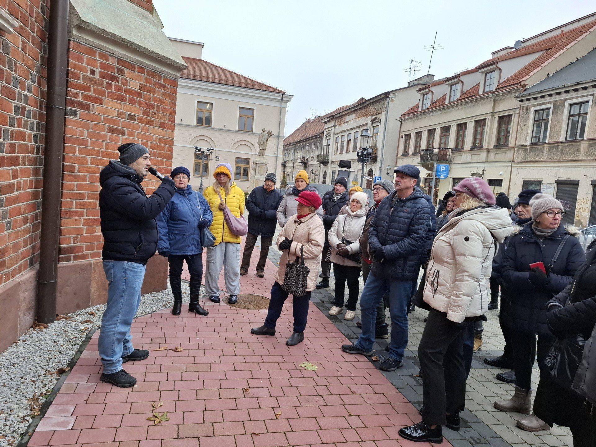 Interesujące informacje na temat zapomnianych miejsc pochówków przekazywał Paweł Puton z Resursy Obywatelskiej. Na zdjęciu uczestnicy spaceru przy  radomskiej farze.