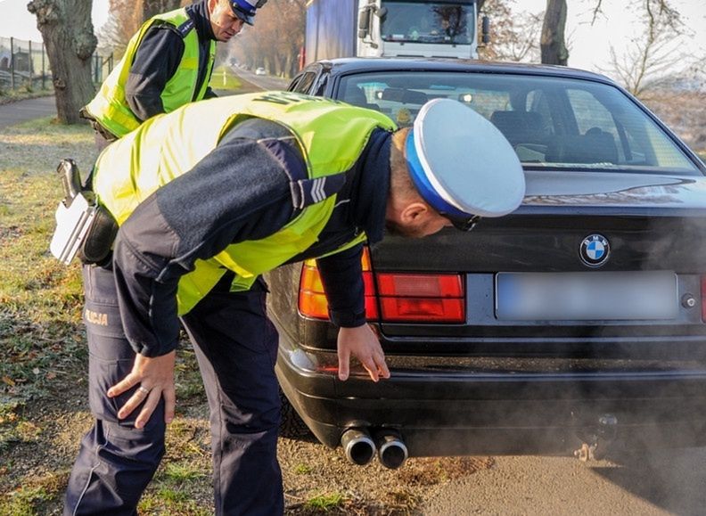 Policja kontroluje samochód. Smog, spaliny