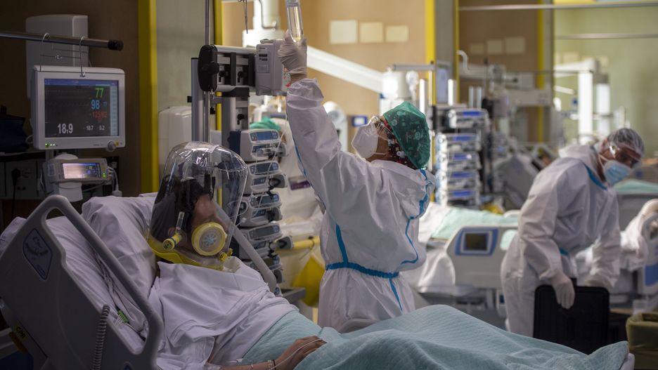 ROME, ITALY - DECEMBER 17: A Covid-19 patient wearing the CPAP mask is treated by health workers in the Intensive Care Unit (ICU) at the Covid Emergency department of the Umberto I Hospital, during the Coronavirus pandemic on December 17, 2020, in Rome, Italy. There have been over 1,870,000 reported coronavirus (COVID-19) cases in Italy and more than 65,857 related deaths since the beginning of the pandemic. (Photo by Antonio Masiello/Getty Images)