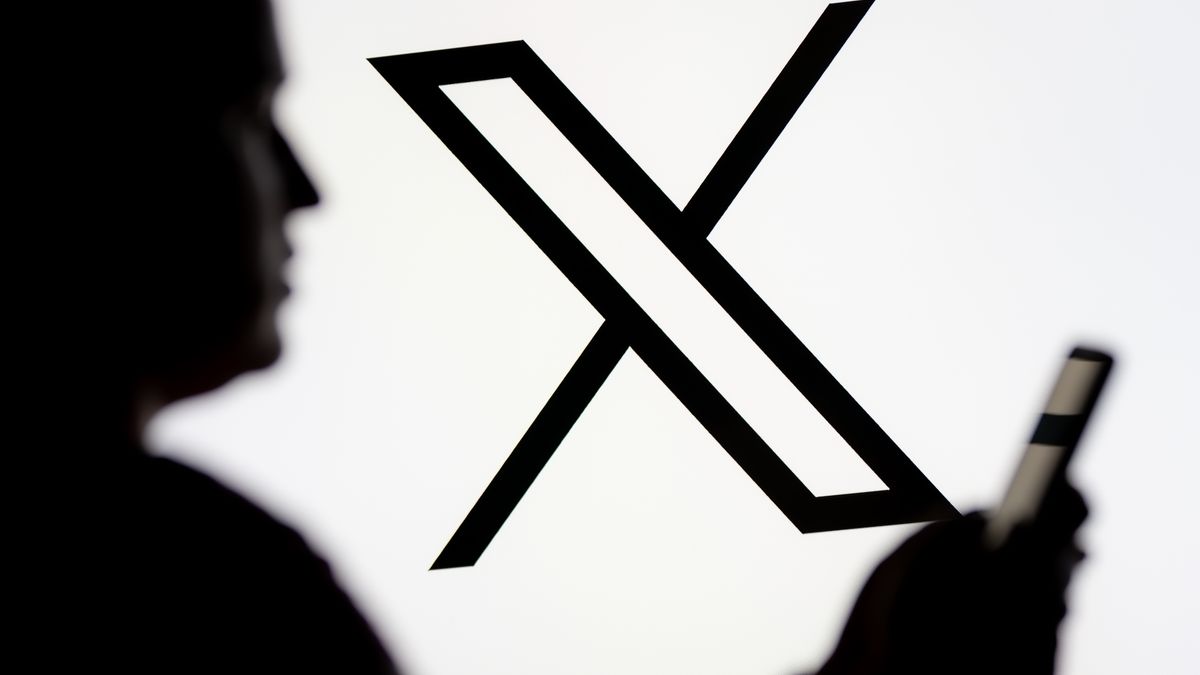 POLAND - 2025/03/07: In this photo illustration, a woman seen looking at a smartphone with the X (Twitter) logo displayed in the background. (Photo Illustration by Mateusz Slodkowski/SOPA Images/LightRocket via Getty Images)