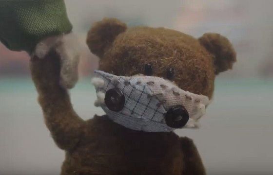 Dziewczynka szyje maskę antysmogową dla misia w kampanii Greenpeace (wideo)