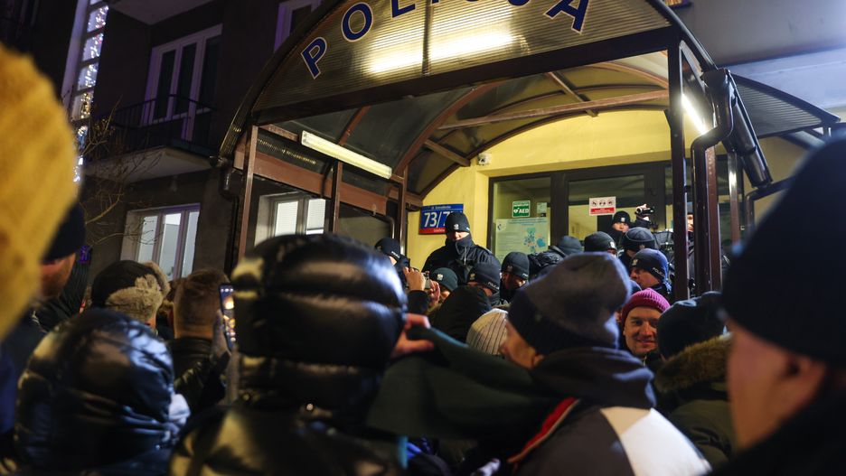 Warszawa, 09.01.2024. Uczestnicy protestu przed Komendą Rejonową Policji przy ul. Grenadierów w Warszawie, 9 bm. Protestujący zebrali się przed komendą w związku z informacją, że trafili tu zatrzymani w Pałacu Prezydenckim Mariusz Kamiński oraz Maciej Wąsik. Zatrzymani politycy zostali następnie przewiezieni do Aresztu Śledczego Warszawa-Grochów. (jm) PAP/Rafał Guz