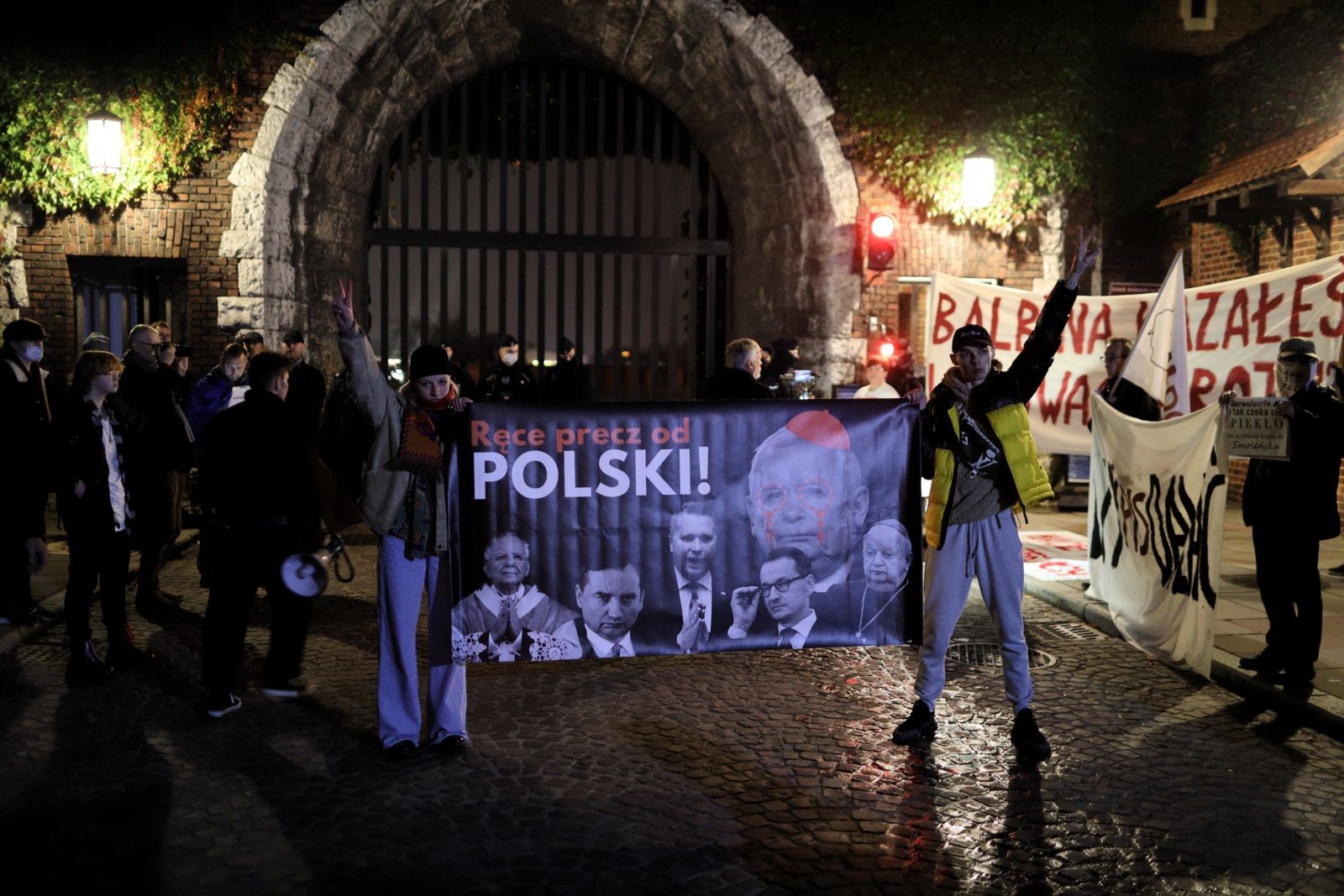 Kraków, 18.10.2021. Protestujący na drodze, którą przejeżdżają politycy PiS na mszę świętą w katedrze na Wawelu, 18 bm. Politycy PiS odwiedzają katedrę w miesięcznicę pogrzebu pary prezydenckiej Lecha i Marii Kaczyńskich