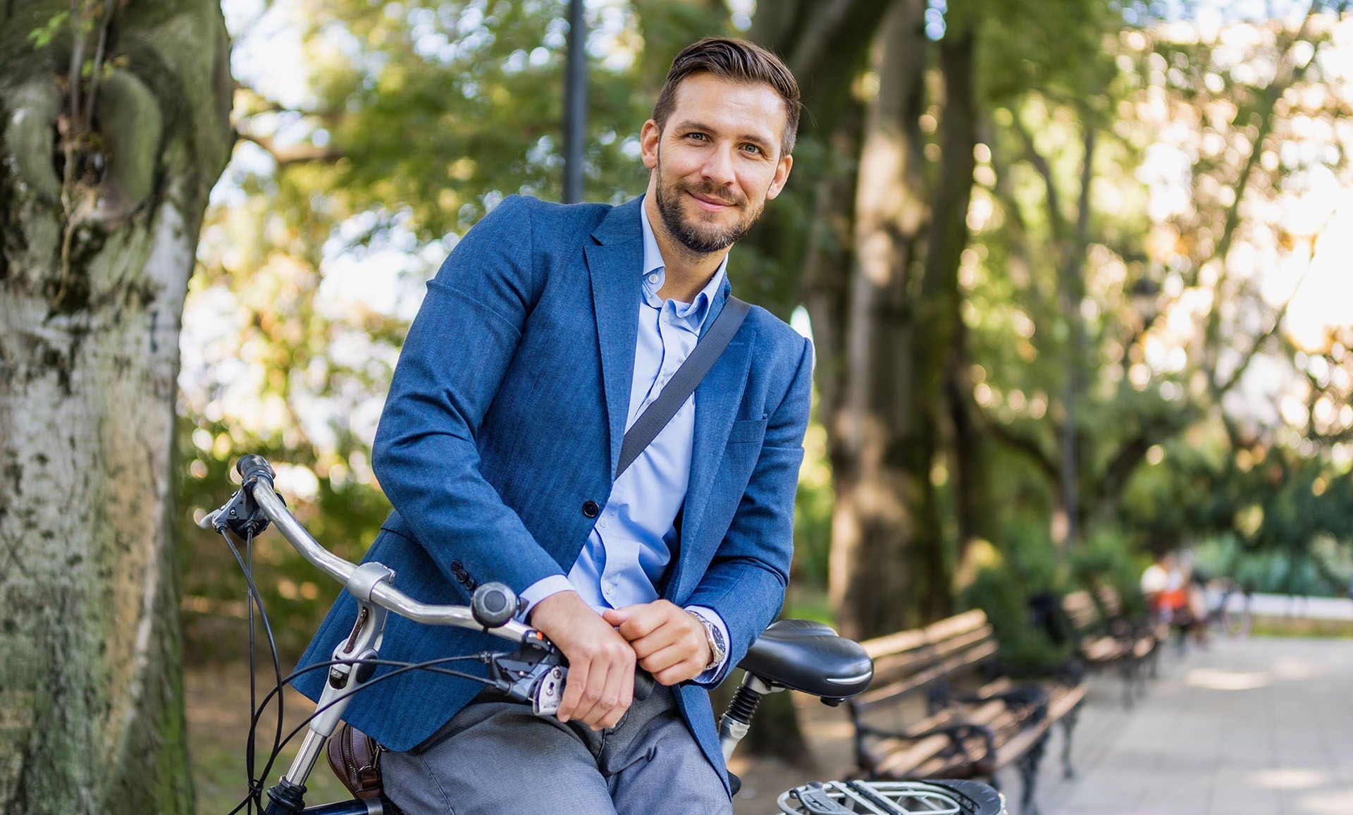  Uśmiechnięty mężczyzna na rowerze w parku - tytułowa