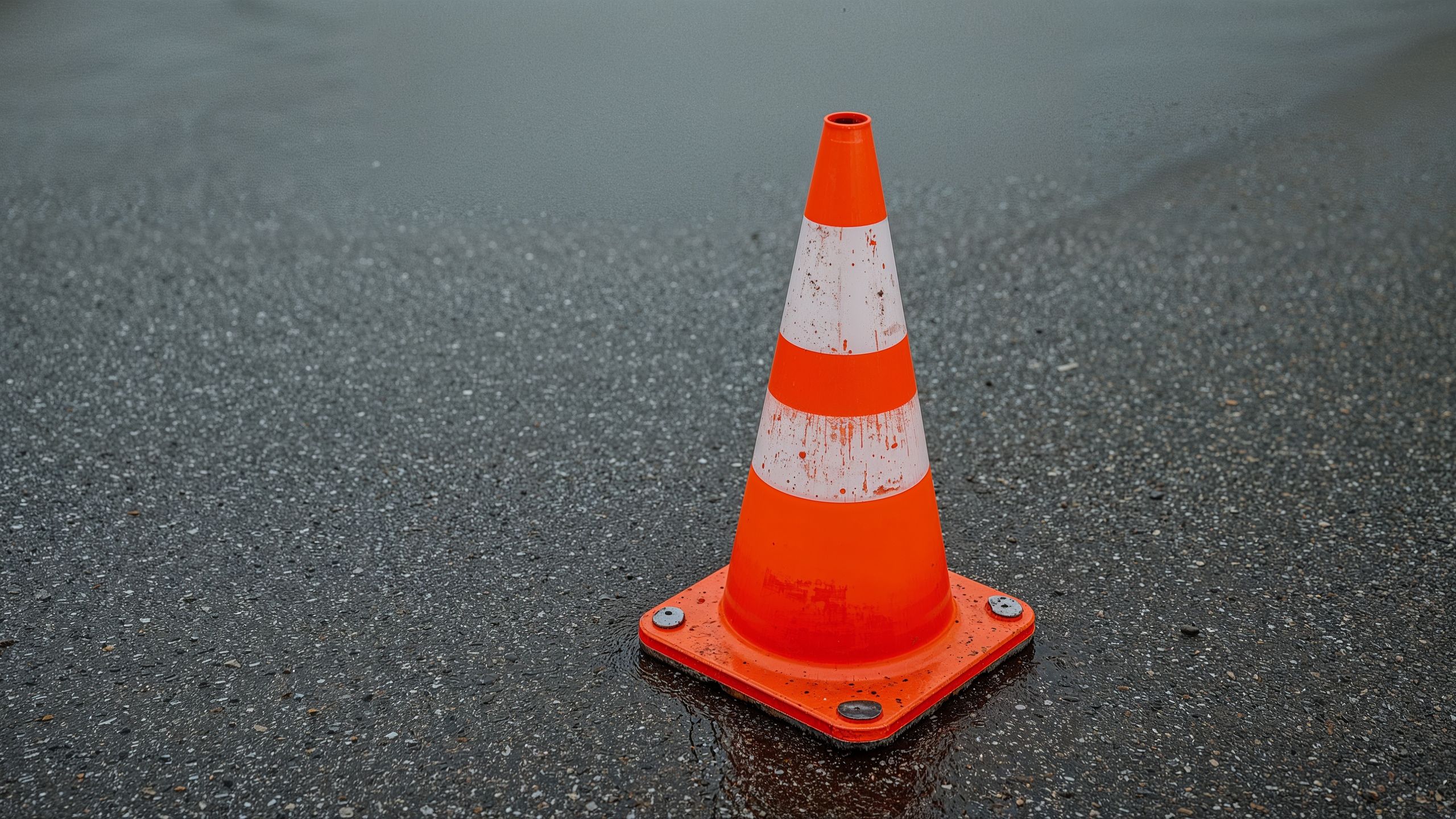 safety, orange, cone, wet, asphalt, rain, plastic, traffic, road, maintenance, work, construction, highway, alert, warning, transportation, infrastructure, street, city, outdoor, safety equipment, visibility, bright, reflective, urban, roadwork, caution, signaling, emergency, vehicle, detour, neighborhood, public safety, maintenance work, storm, puddles, rain-soaked, rubber, design, industry, safety gear, traffic control, cones, prevention, hazard