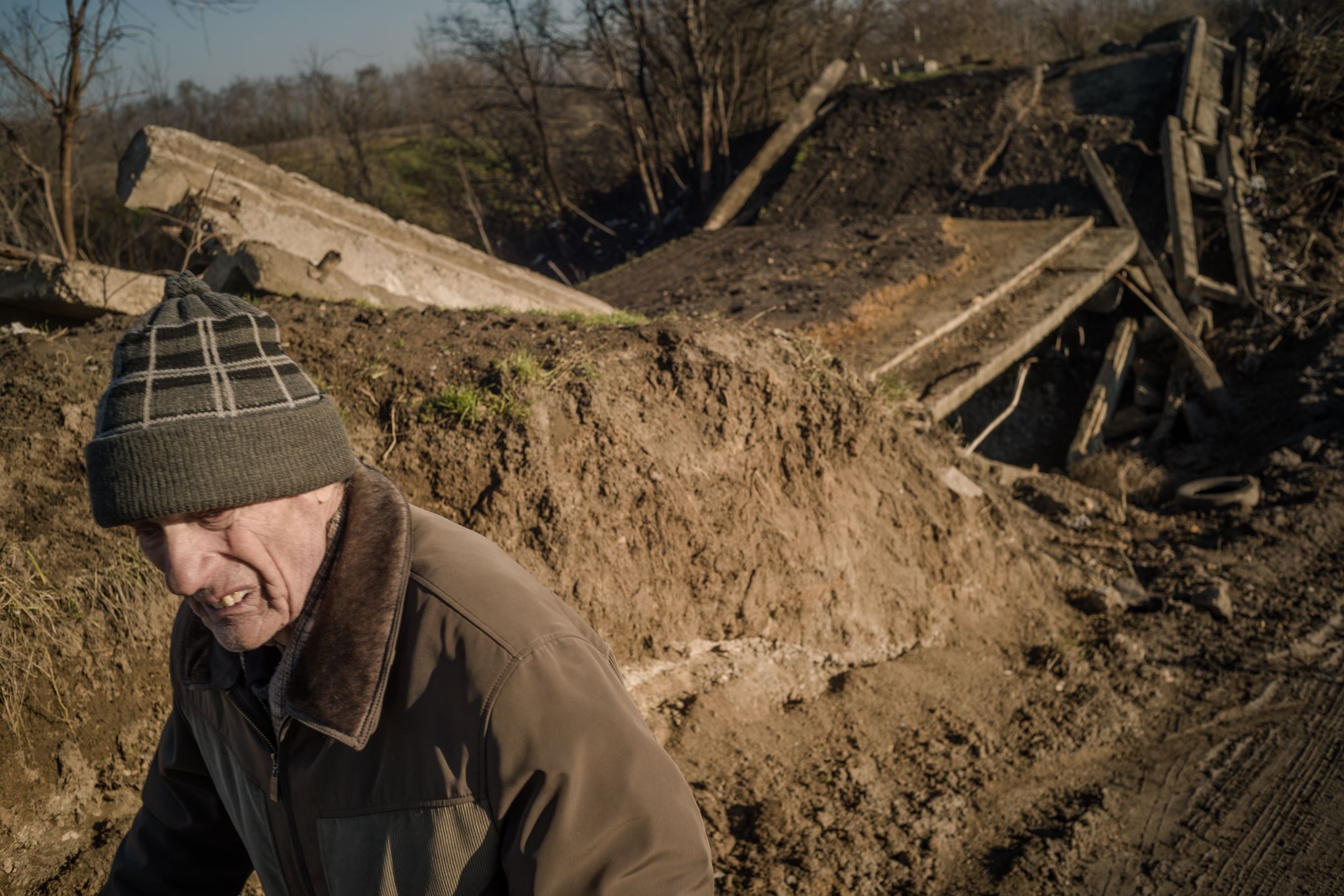 Petro Semenowycz stoi nieopodal zniszczonego mostu we wsi Prawdyne.  Przed wojną żyło tu około 1700 osób. Obecnie - mniej niż 200. Od dwóch miesięcy wieś nie ma prądu. Ale codziennie ktoś powraca do domu. 

Rosjanie okupowali Prawdyne od marca 2022 r. Mieszkańcy mówią, że rosyjska armia zachowywała się spokojnie wobec nich, ale potem jej miejsce zajęli żołnierze z samozwańczych republik donieckiej i ługańskiej. I zaczęli wszystko kraść. Jak tylko odeszli, a przyszła armia ukraińska, Rosjanie zaczęli ostrzeliwać wieś. Szkoła, przedszkole, budynek wiejskiej rady i wiele domów zostało zniszczonych. Rosjanie wysadzili też jedyny most wiodący do Chersonia. Trwa zima, i kiedy robi się ślisko, żaden samochód nie przejedzie stromym objazdem.