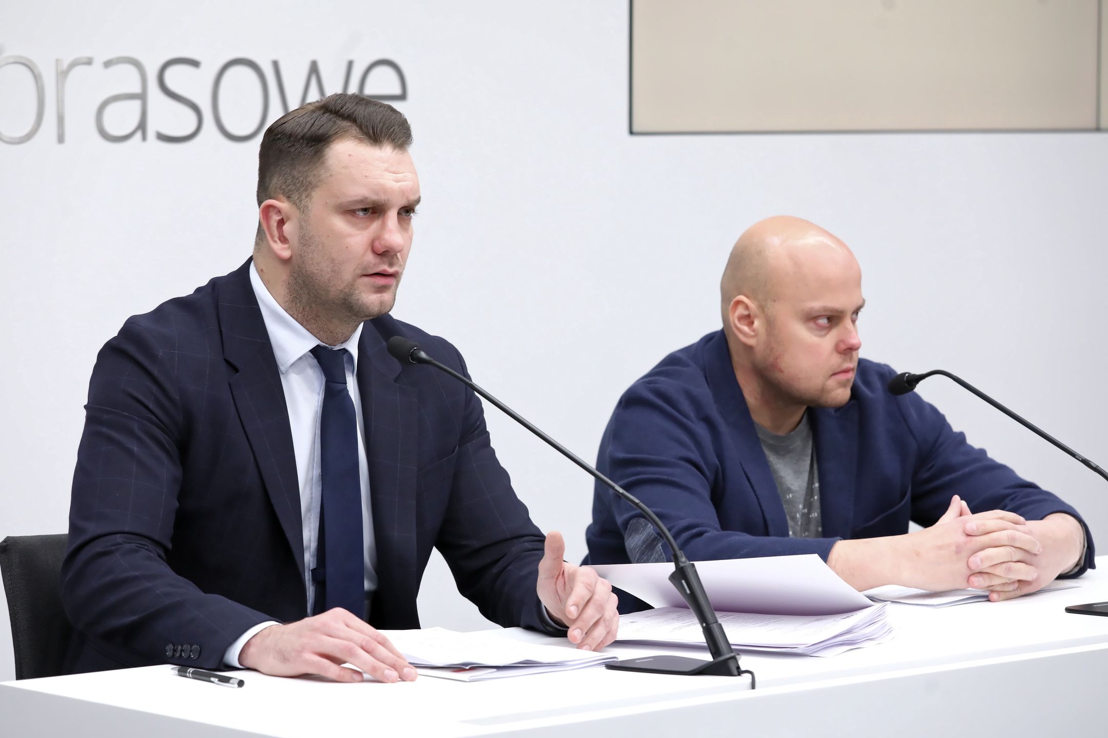Warszawa, 08.12.2021. Poseł PiS, wiceminister sportu Łukasz Mejza (L) i były pacjent firmy farmaceutycznej wiceministra Mejzy Tomasz Guzowski (P) biorą udział w konferencji prasowej w Centrum Prasowym PAP w Warszawie, 8 bm. Konferencja dot. informacji przekazanych pod koniec listopada br. przez Wirtualną Polskę, że Łukasz Mejza założył w przeszłości firmę medyczną, która miała się specjalizować w kosztownym leczeniu nowatorskimi metodami chorych na raka, Alzheimera czy Parkinsona. Według portalu interes Mejzy nie wyszedł, za to pozostawił po sobie wielu oszukanych pacjentów i ich rodziny. (aldg) PAP/Tomasz Gzell