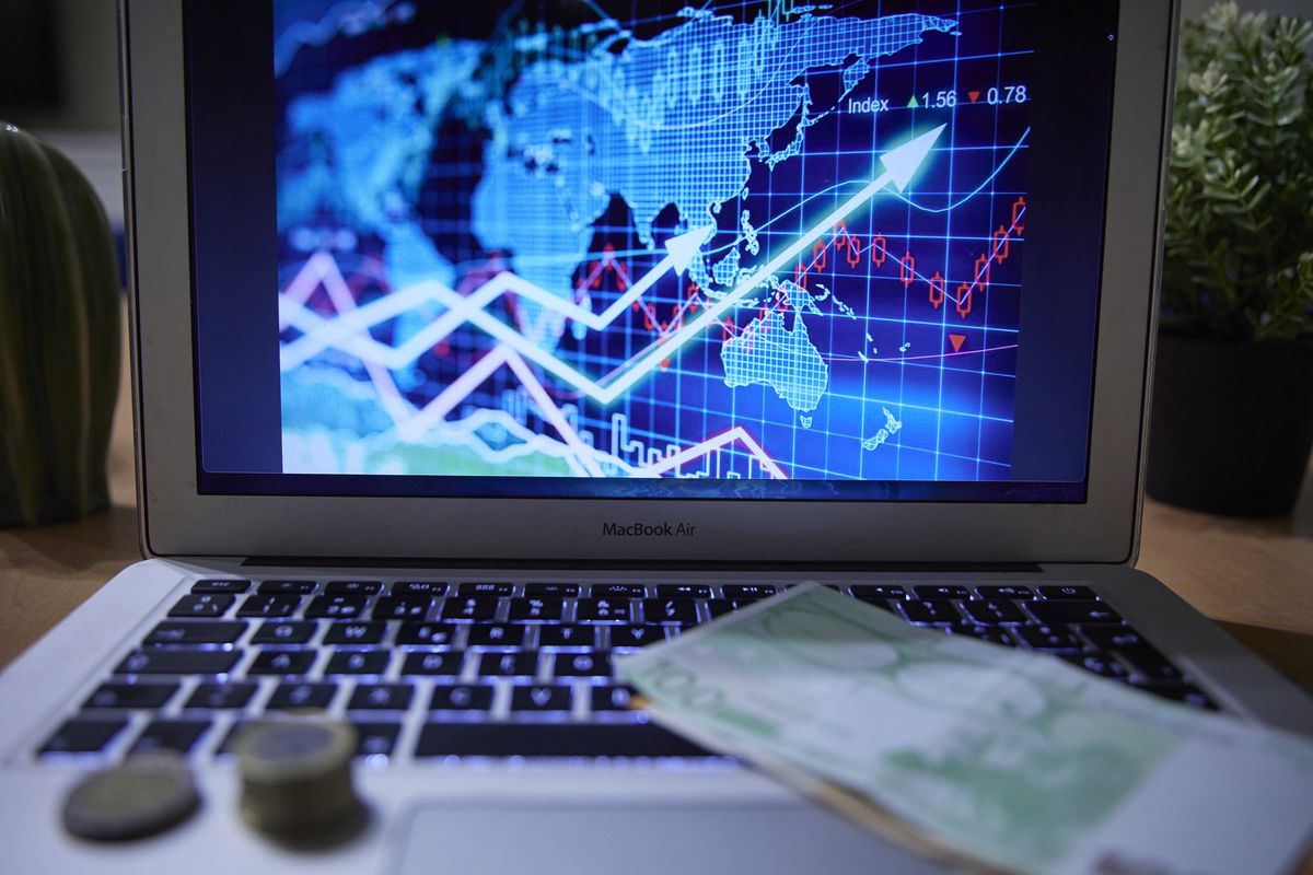 MADRID, SPAIN - JANUARY 04: A chart on a laptop computer with banknotes and coins, on 4 January 2022, in Madrid, Spain. The General Council of Economists estimates that the Spanish economy will grow by 5.6% in 2022. It also warns of the dangers of the rebound in the Consumer Price Index (CPI) and the rise in core inflation. (Photo By Jesus Hellin/Europa Press via Getty Images)