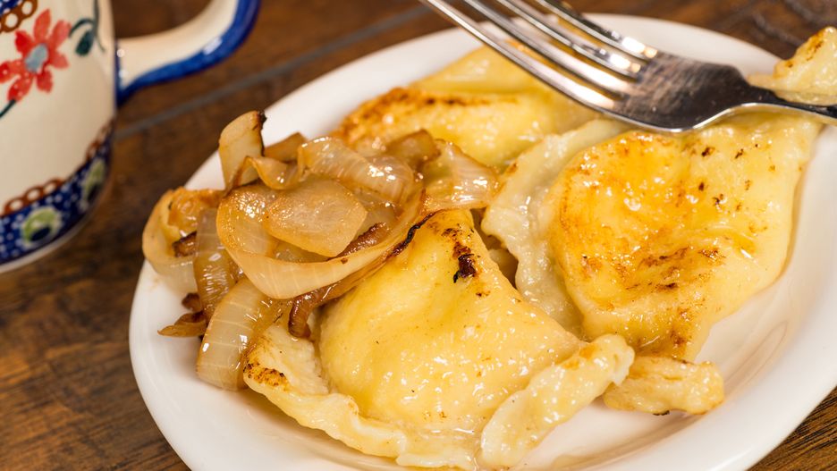 A plate of handmade pierogi with a side of carmelized onions.  There is a silver fork on the plate, as well as a colorful mug in the background.  Everything is shot on a wood table.
Mark Skalny
Pierogi, Polish Cuisine, Food, stuffed, onion, cooked, fork, wood, table, Christmas, Dinner, Holiday, Plate, Selective Focus, Celebration, Meal, Close-up, traditional, delicious, carmelized, silver, mug, colorful, white plate, handmade, homemade, semicircular, dumpling, horizontal, pierogi, polish cuisine, food, stuffed, onion, cooked, fork, wood, table, christmas, dinner, holiday, plate, selective focus, celebration, meal, close-up, traditional, delicious, caramelized, silver, mug, colorful, white plate, handmade, homemade, semicircular, dumpling, horizontal