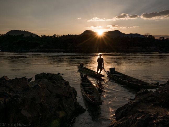 Rybak Kham wypływa o zachodzie słońca na połów na rzece Mekong, na pograniczu Laosu i Kambodży, 2017 r.