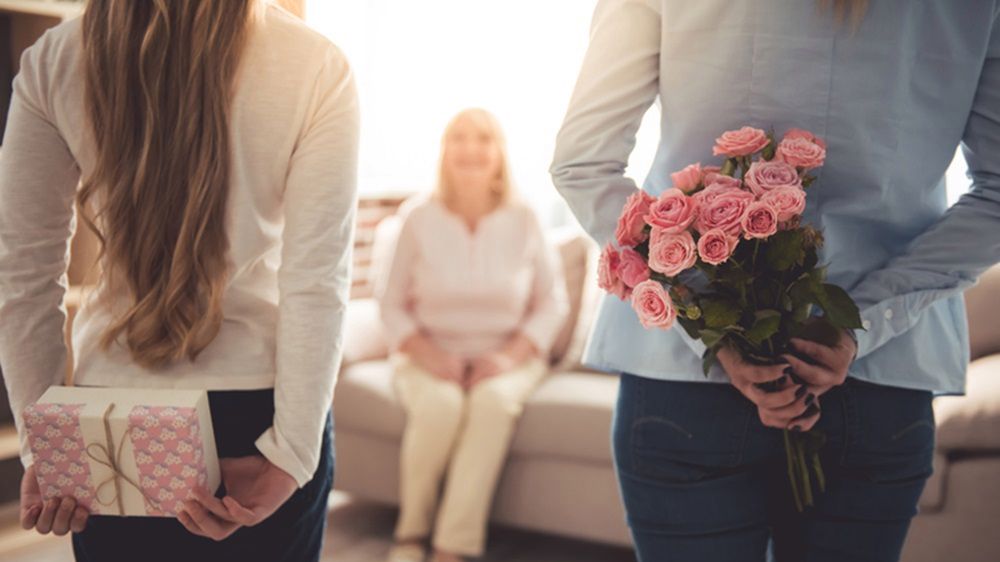 Świąteczny zestaw kosmetyków pięknie zapakowany oraz bukiet kwiatów na pewno spodoba się mamie