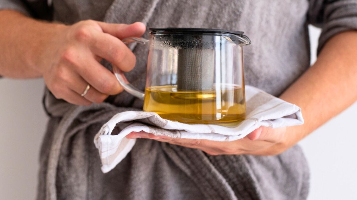 Kobieta trzyma w dłoniach dzbanek naparu
