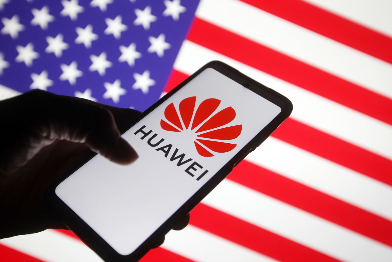 UKRAINE - 2021/01/19: In this photo illustration a Huawei logo is seen displayed on a mobile phone with the U.S. flag in the background.
 The US notified Huawei suppliers to revoke some licenses, reportedly by media. (Photo Illustration by Pavlo Gonchar/SOPA Images/LightRocket via Getty Images)