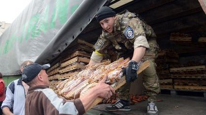 Ukraiński żołnierz rozdaje żywność mieszkańcom odbitego z rąk rosyjskich separatystów Słowiańska.
