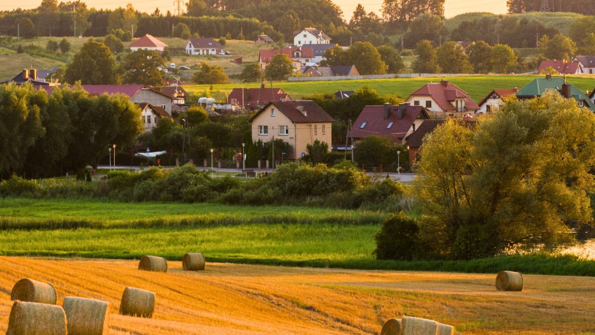 Krajobraz polskiej wsi z domami i belami słomy