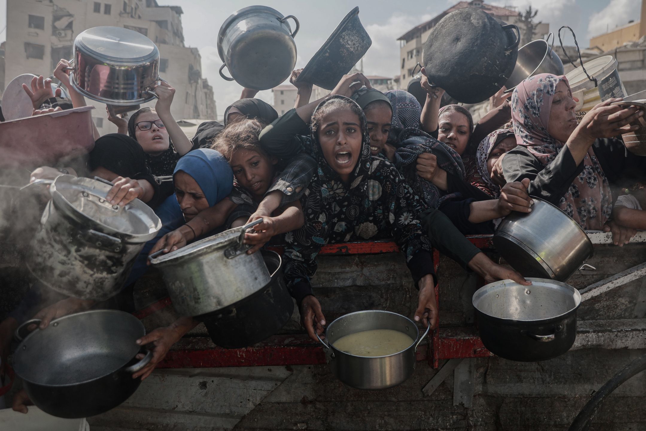 Palestyńczycy czekający na jedzenie od organizacji charytatywnej