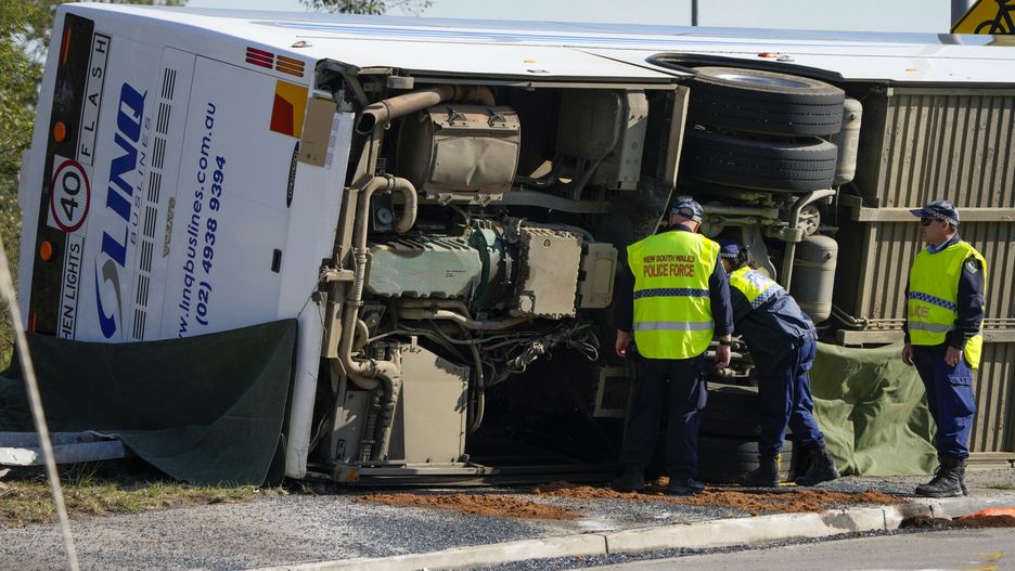 Policja sprawdza pod autobusem, który przewrócił się na bok w pobliżu Grety w Hunter Valley, na północ od Sydney, Australia, poniedziałek, 12 czerwca 2023 r.