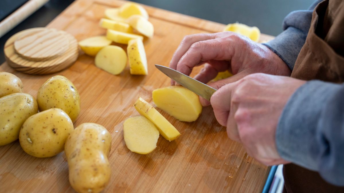 Kobieta kroi ziemniaki w plasterki